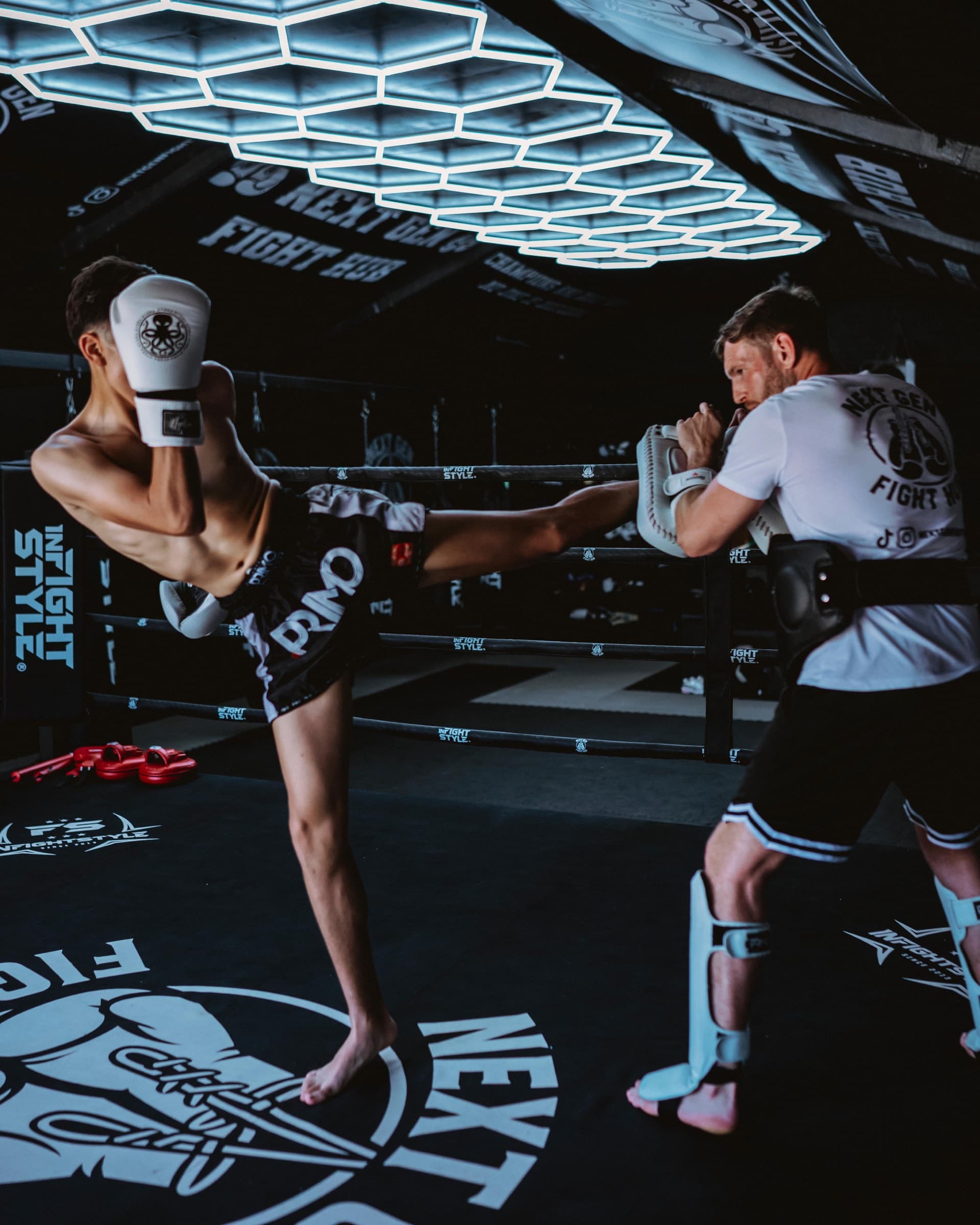 Pad work under the ring lights at Next Gen Fight Hub